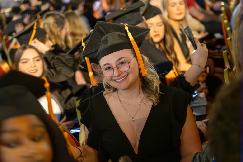 étudiante souriante et fière d'avoir réussi à obtenir un diplome en master en alternance